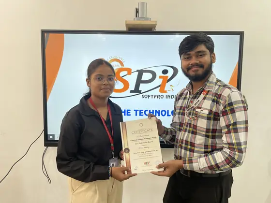 A student receiving her certificate in front of the SSS India screen