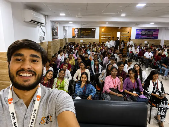 A SSS trainer taking a selfie with a hall of students filling the frame behind